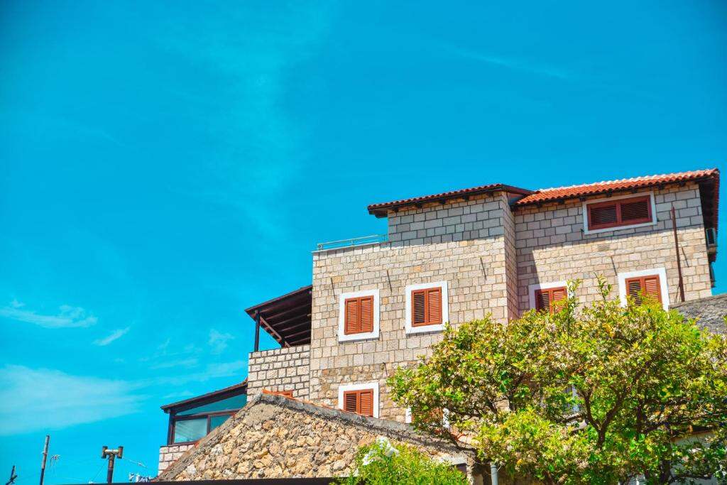 The villa rising above the old town rooftops under a clear blue sky