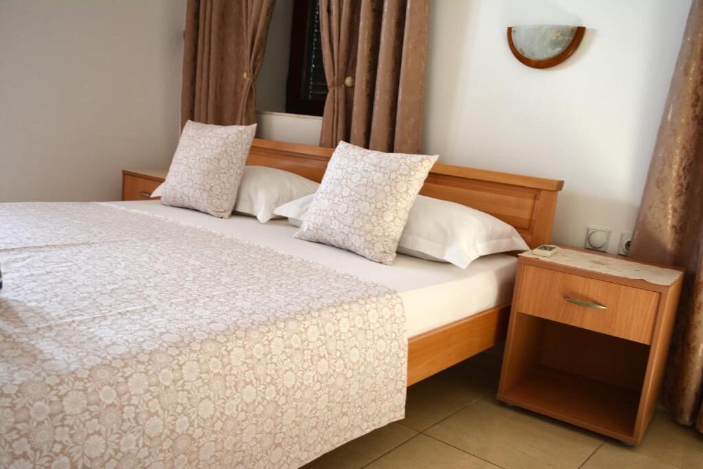 Bedroom with a wooden bed frame, patterned bedspread and bedside table